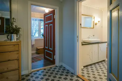a bathroom with a sink and a door leading to a bathroom at Family-Friendly Cabin With Agricultural Idyll in Vestre Gausdal
