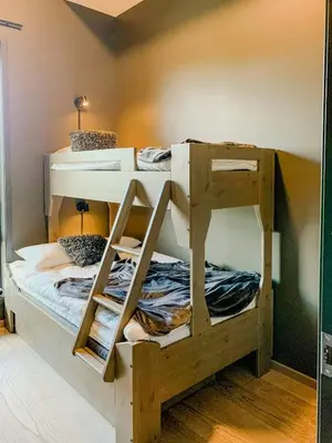 two bunk beds in a room with a ladder at Modern Flat In Trysil Alpine Lodge in Trysil