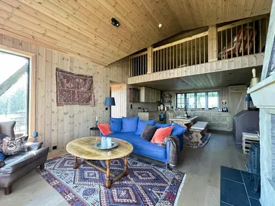 a living room with a blue couch and a table at Peaceful Cabin By Rødungen in Ål