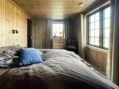 a bedroom with a bed with a blue pillow on it at Peaceful Cabin By Rødungen in Ål