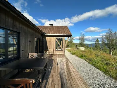 a house with a wooden deck next to a building at Peaceful Cabin By Rødungen in Ål