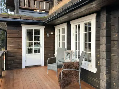 a patio with a table and chairs on a house at Mountain Home At Haglebu With Activities in Eggedal