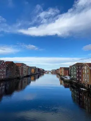 a river with houses and buildings on the sides at Stilig bryggeleilighet i Trondheim sentrum in Trondheim