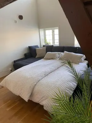 a bedroom with a large bed and a couch at Stilig bryggeleilighet i Trondheim sentrum in Trondheim