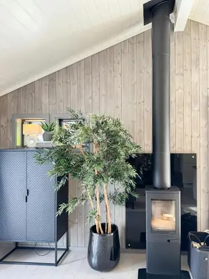 a room with a fireplace with a tree in front of it at Luxury By The Fjord In Ranvik in Eidsvåg