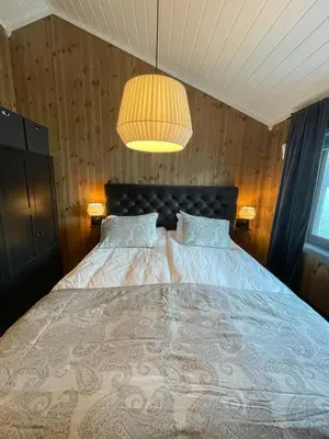a bedroom with a large bed and a lamp at Luxury By The Fjord In Ranvik in Eidsvåg