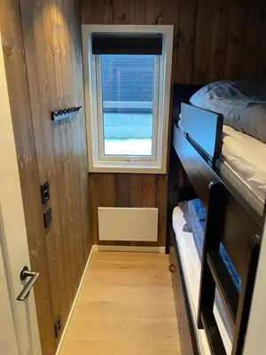 a small room with two bunk beds and a window at Hafjell Alpinlandsby Apartment 43 in Hafjell