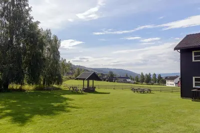 a picnic area with picnic tables in a field at Hafjell Alpinlandsby Apartment 43 in Hafjell