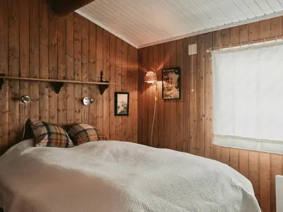 a bedroom with a bed with wooden walls and a window at Cabin In Uvdal With A View Ski-Inout in Uvdal