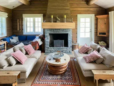 a living room with couches and a fireplace at Spacious Family Cabin Near Nordre Syndin in Ryfoss