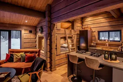 a log cabin kitchen with a stove and a couch at Cabin With Great Fishing At Trysilfjellet in Jordet
