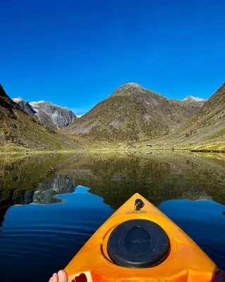 a person in a kayak on a body of water at A home away from home in Sogndal