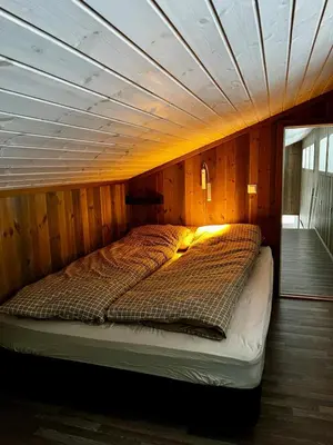 a bed in a room with a wooden ceiling at A home away from home in Sogndal