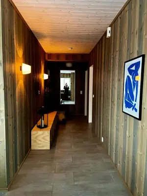 a hallway with wood paneled walls and a mirror at A home away from home in Sogndal