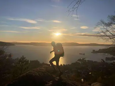 a person with a backpack standing on top of a mountain at In the heart of Bergen in Bergen