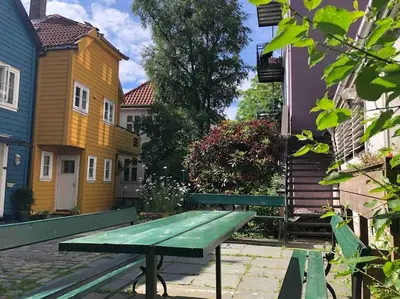 a green picnic table in a courtyard with houses at In the heart of Bergen in Bergen