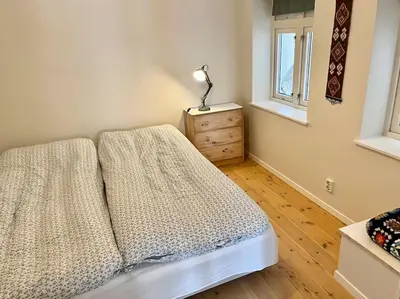 a bedroom with a bed and a lamp on a dresser at In the heart of Bergen in Bergen