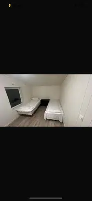 a room with two beds and a tv in it at et fint og stort enebolig sentralt i voss! in Vossevangen