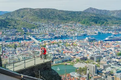 two people standing on top of a bridge overlooking a city at Hotel Oleana in Bergen