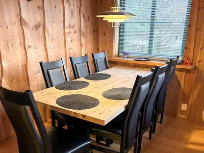 a dining room table with black chairs and a wooden table at 4 person holiday home in Kjerrgarden in Kjerrgarden