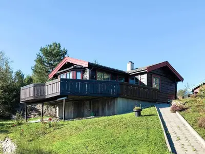 a house with a large deck on a yard at 4 person holiday home in Kjerrgarden in Kjerrgarden