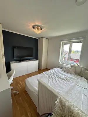 a bedroom with a large bed and a flat screen tv at World championship, VM på ski Granåsen 2025 in Trondheim