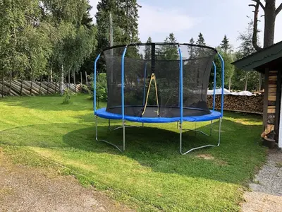a small trampoline in the grass in a yard at Cozy cabin 1,5 hours from Oslo in Hamar