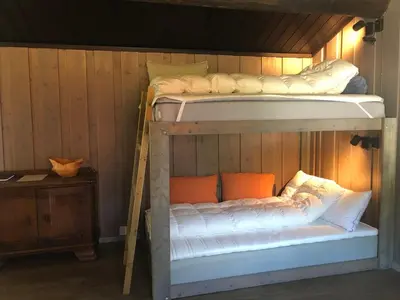 two bunk beds in a room with a wooden wall at Cozy cabin 1,5 hours from Oslo in Hamar
