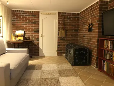 a living room with a couch and a brick wall at Cabin with large outdoor area in Hamar