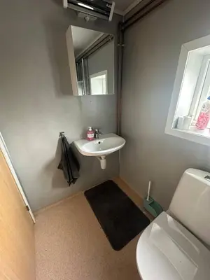 a bathroom with a sink and a toilet and a mirror at Turifoss Camping Cabin 2 in Svedjan