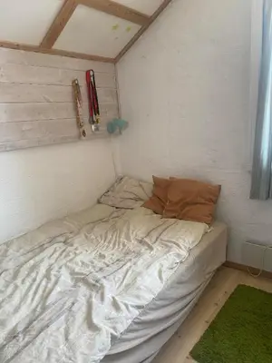 a small bed in a corner of a room at SKI VM House 5 min walk to Granåsen ski stadion in Trondheim