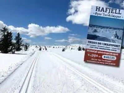a snowy road with a sign in the snow at Modern cabin Hafjell high standard ski-in out in Hafjell
