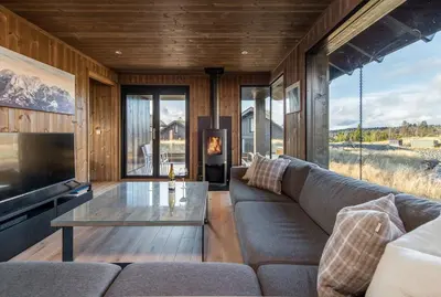 a living room with a couch and a glass table at Modern cabin Hafjell high standard ski-in out in Hafjell
