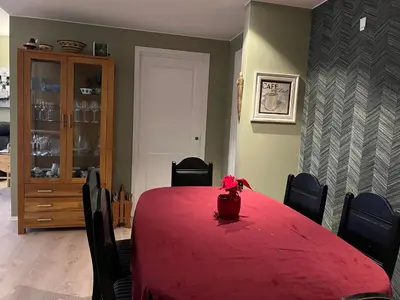a dining room with a red table with chairs and a vase at Attraktiv utsiktsleilighet in Ranheim