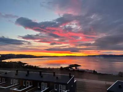 a view of a sunset over a body of water at Attraktiv utsiktsleilighet in Ranheim