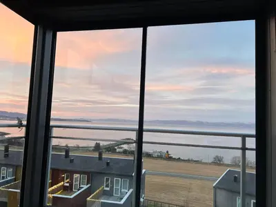 a view of the ocean from a window at Attraktiv utsiktsleilighet in Ranheim