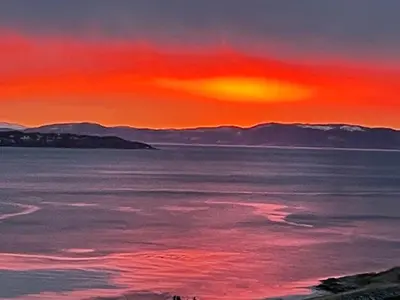 a painting of a sunset over a body of water at Attraktiv utsiktsleilighet in Ranheim