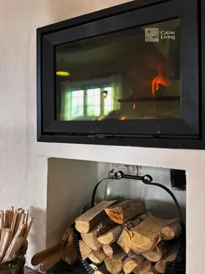 a fireplace filled with fire logs and a tv at Cozy cabin near Geilo & Dagali terrace, grill, fireplace, view & WiFi in Hol