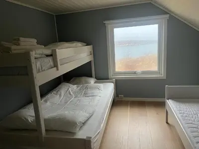 a bedroom with two bunk beds and a window at Idyllisk perle ved sjøen! in Frøya