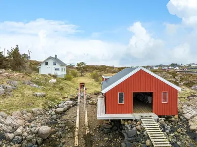 a red house on a hill with train tracks at Idyllisk perle ved sjøen! in Frøya