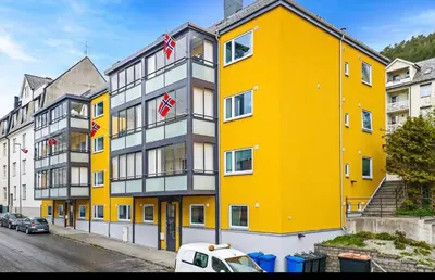 a yellow and white building on a city street at Mint Apartment in Ålesund