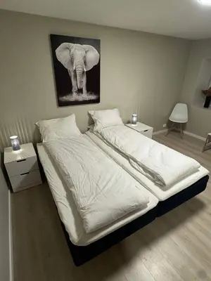 a bedroom with a bed with a picture of an elephant at Mint Apartment in Ålesund