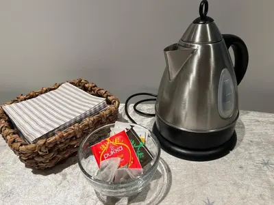 a tea kettle and a basket with a packet of candy at Mint Apartment in Ålesund
