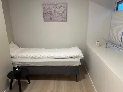 a small room with a bed and a table at Mint Apartment in Ålesund