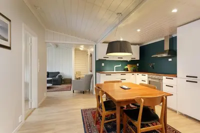 a kitchen with a wooden table and a dining room at Cozy apartment with pool in Bjorli