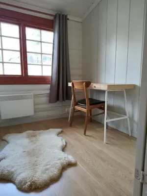 a room with a desk and a chair and a rug at Cozy apartment with pool in Bjorli
