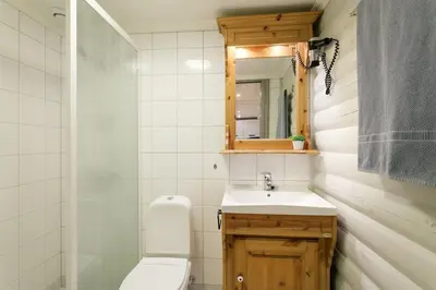 a bathroom with a toilet and a sink and a mirror at Cozy apartment with pool in Bjorli