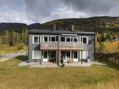 a house on a hill with mountains in the background at Lovely apartment with stunning views in Torset