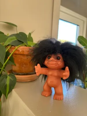 a small doll with black hair standing on a table at Modern & cozy house in Trondheim