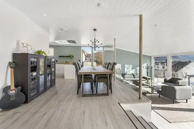 a kitchen and dining room with a table and a guitar at Casa Knott 4 Bedroom in Ulstein
